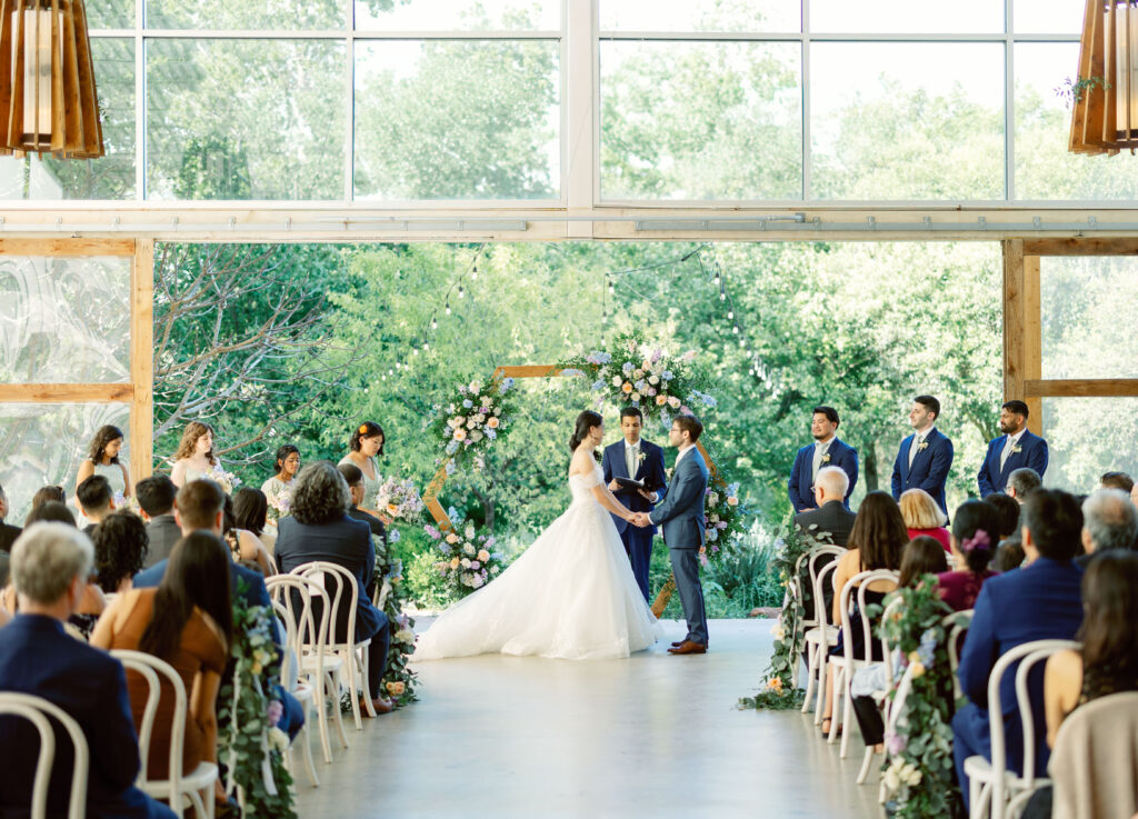 bride and groom stand at altar